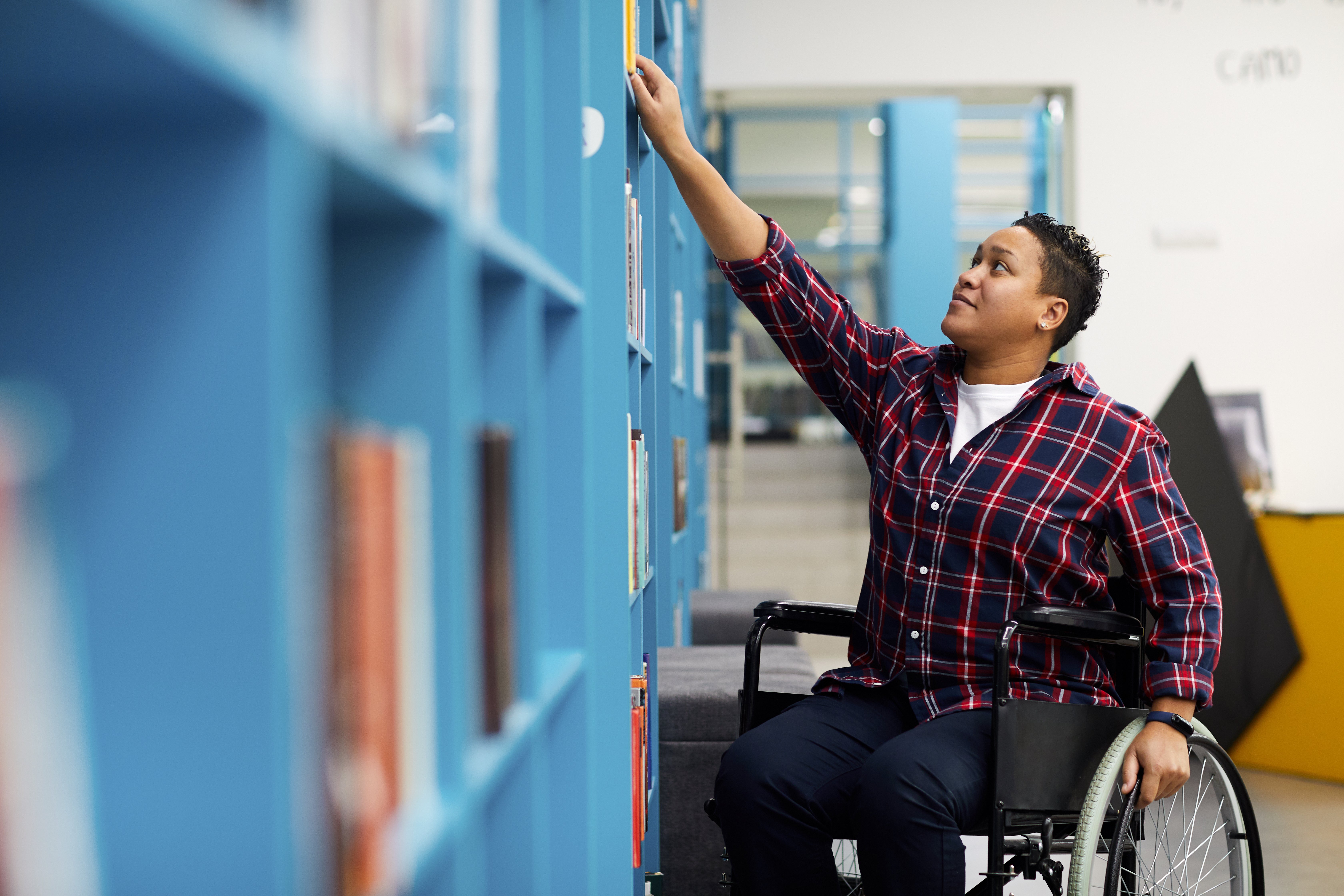 Woman in a wheelchair in a library 