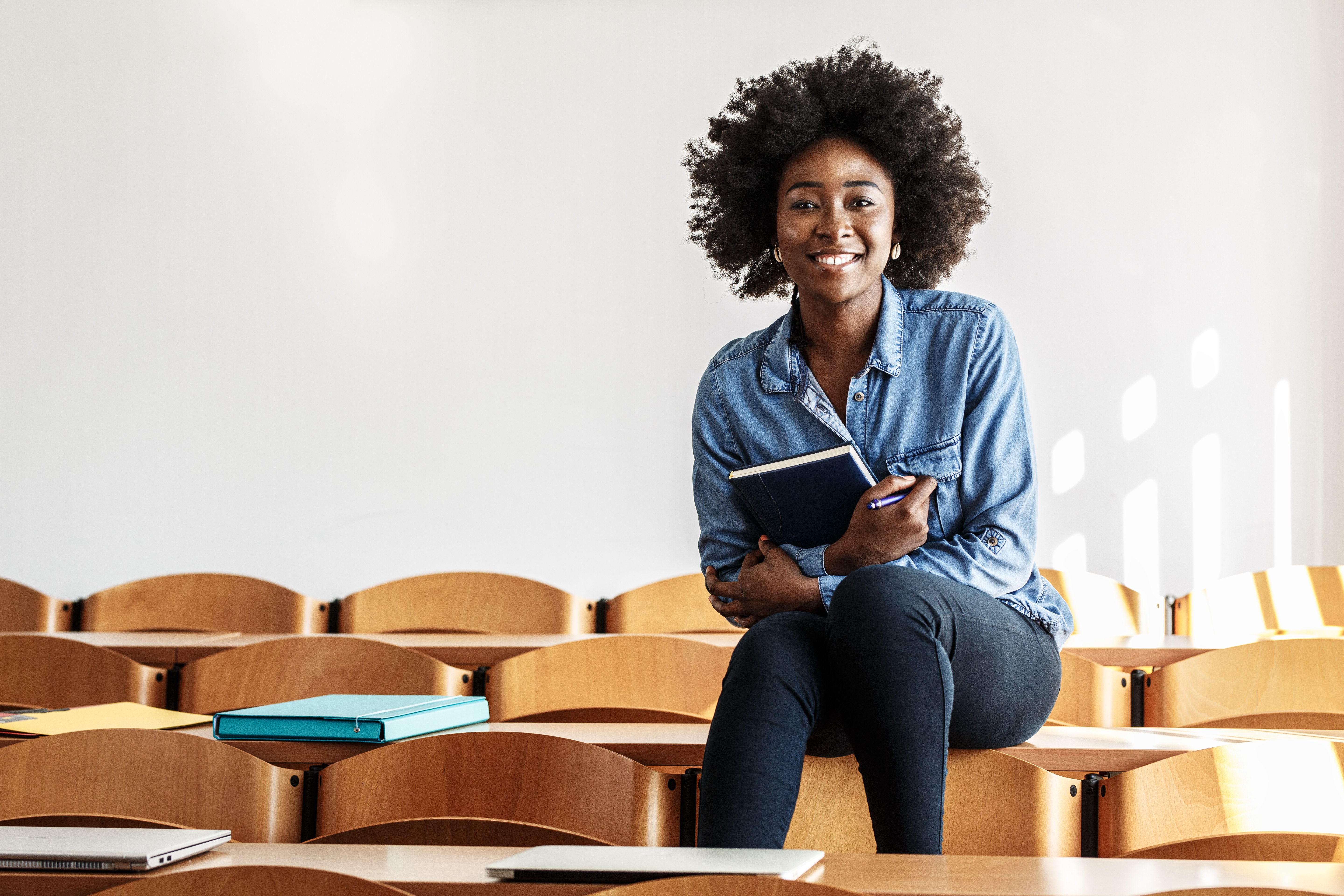 woman in classroom with books in her hands 
