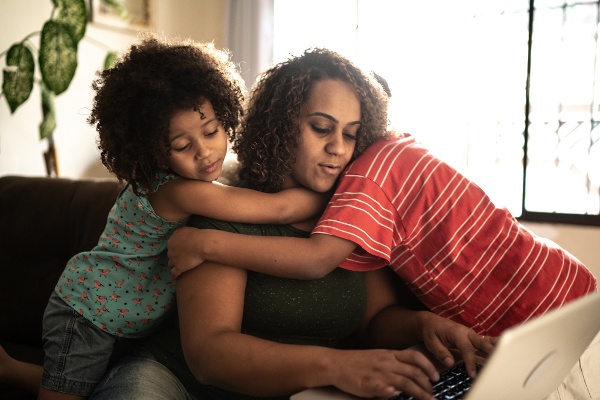 Mom accessing Ad Astra portal with children embracing her