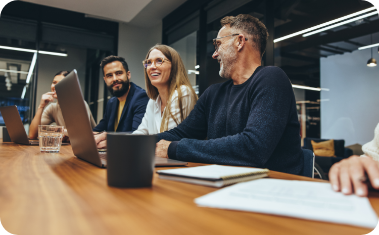 Colleagues laughing around a conference table