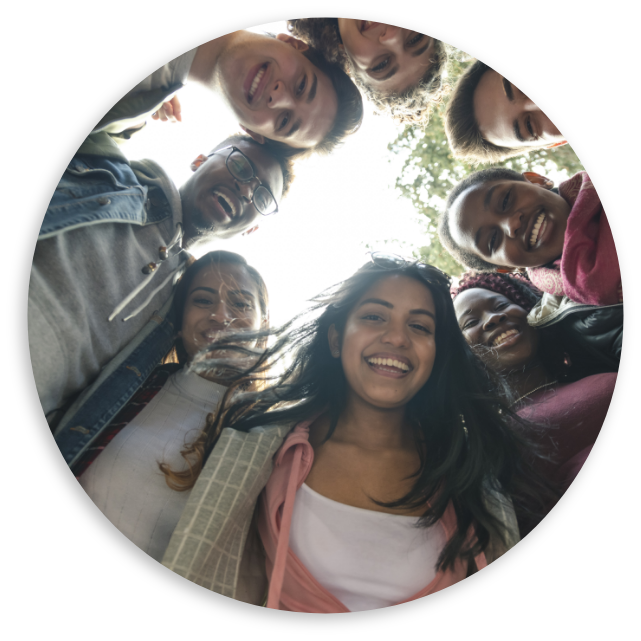 Diverse students embracing looking at camera in a circle